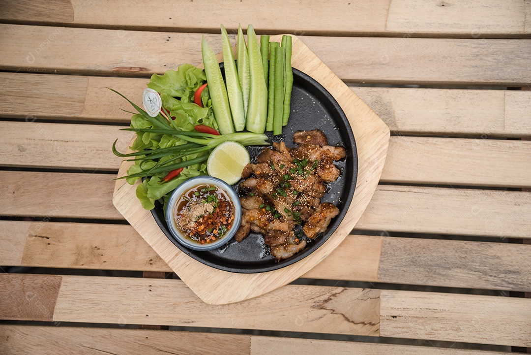 Prato sobre uma mesa de madeira legumes limão carne molho