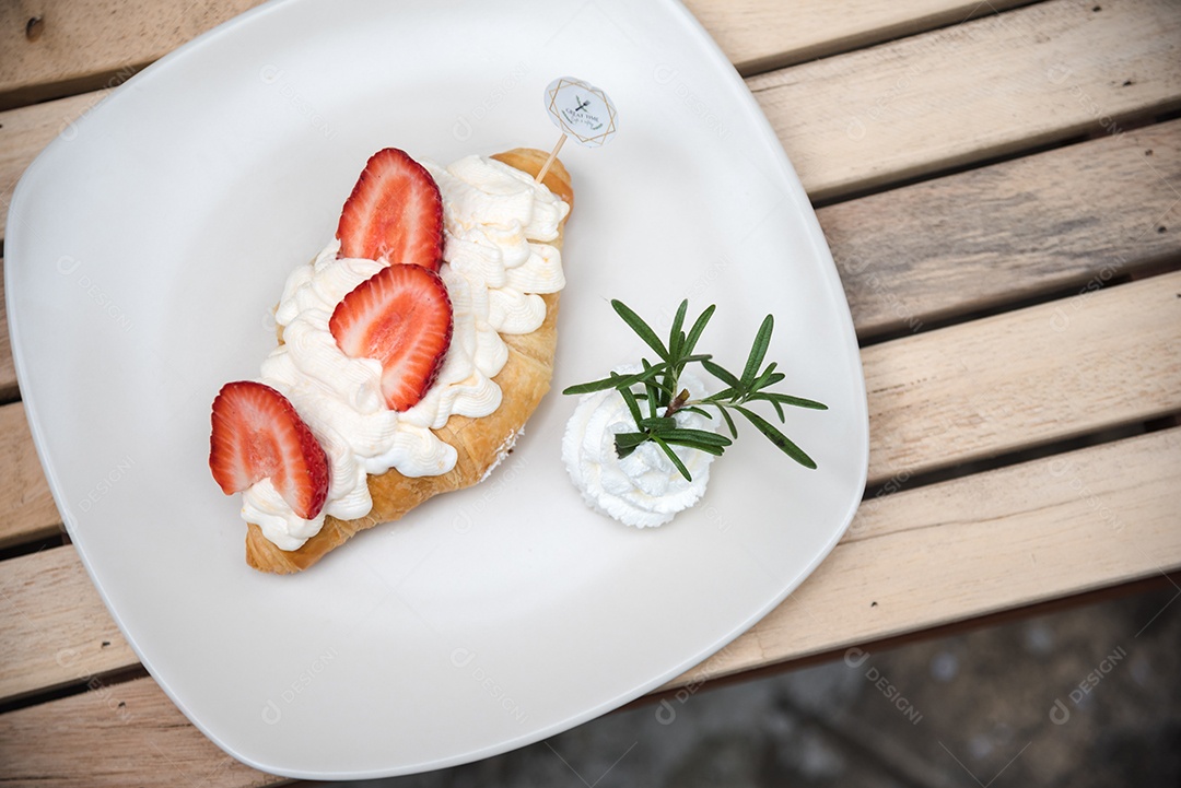Bread on a white plate chantily strawberry cut into made on a wooden table