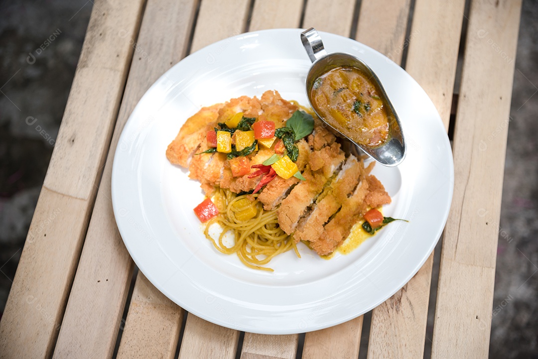 Mãos de pessoa colocando macarronada sobre prato branco mesa madeira