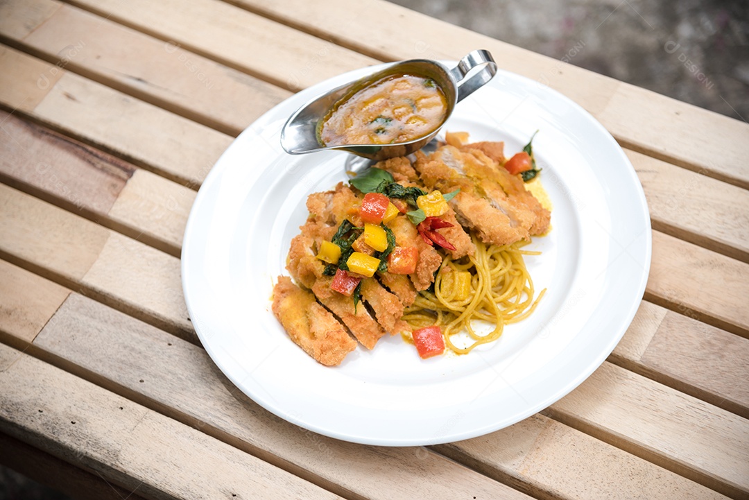 Mãos de pessoa colocando macarronada sobre prato branco mesa madeira