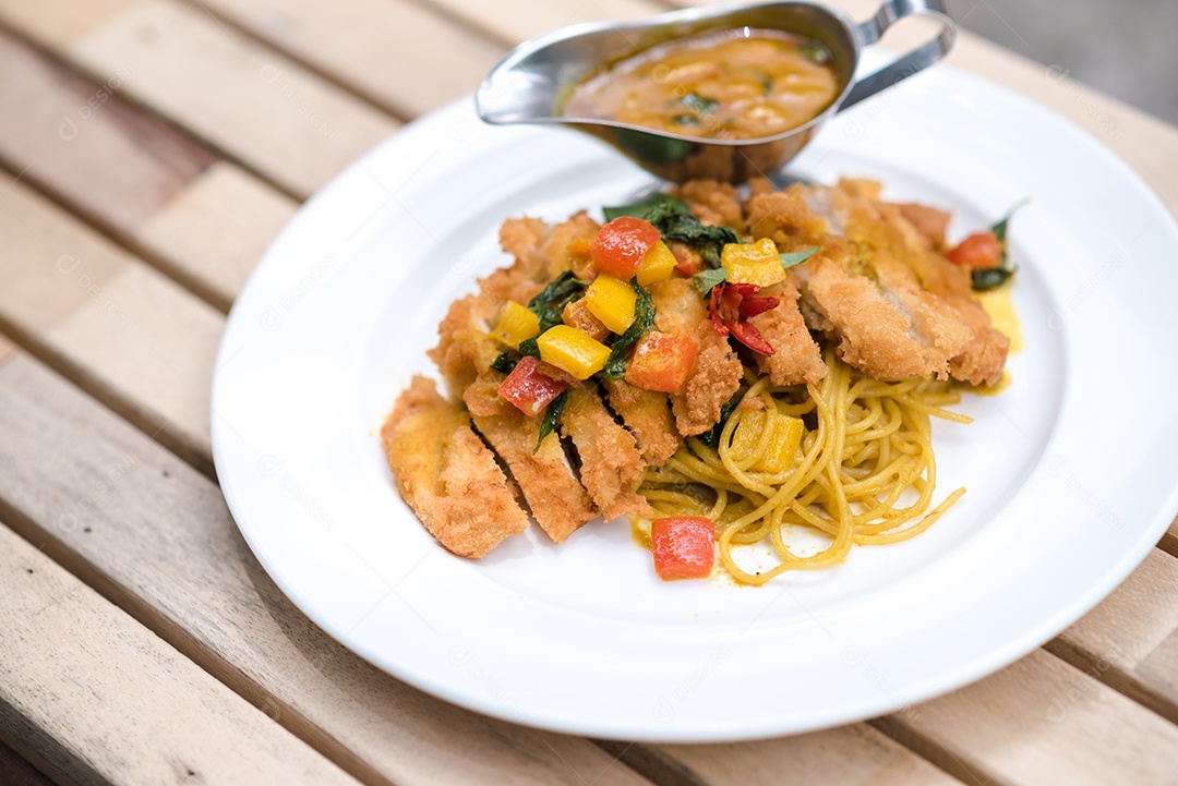 Mãos de pessoa colocando macarronada sobre prato branco mesa madeira
