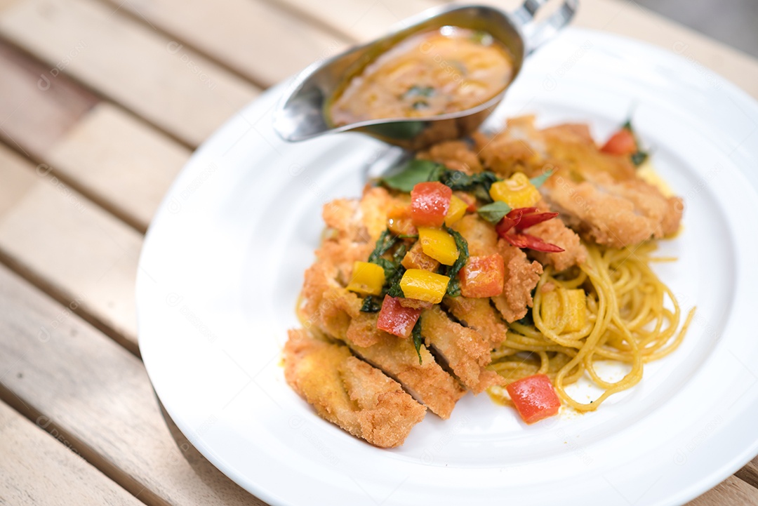 Mãos de pessoa colocando macarronada sobre prato branco mesa madeira