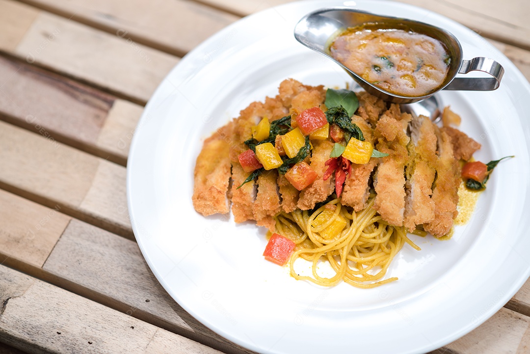 Mãos de pessoa colocando macarronada sobre prato branco mesa madeira