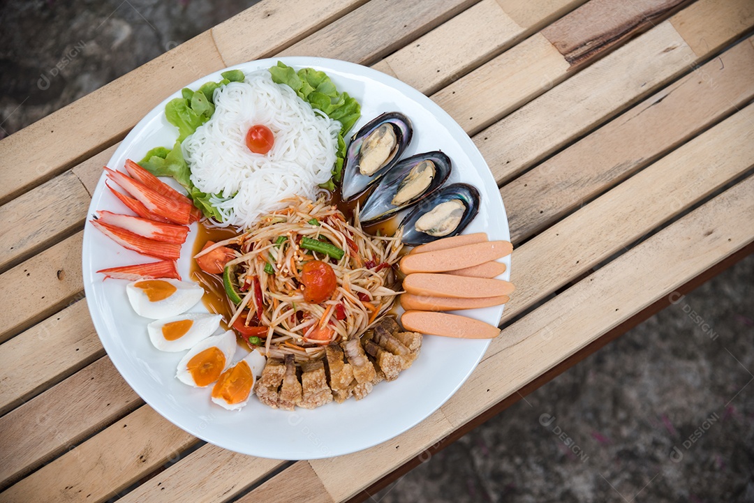 Prato de comida arroz salada legumes torresmo frito sobre uma mesa de madeira