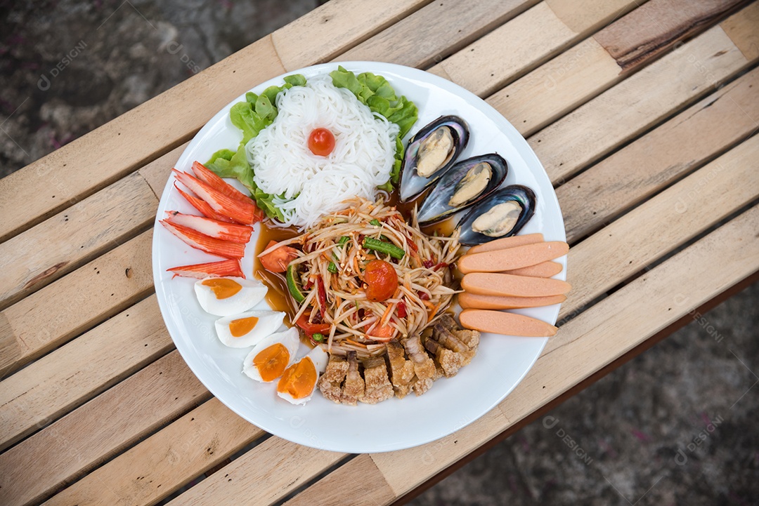 Prato de comida arroz salada legumes torresmo frito sobre uma mesa de madeira