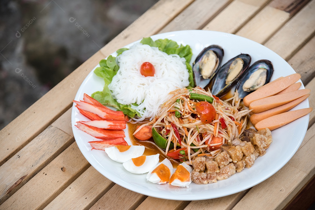 Prato de comida arroz salada legumes torresmo frito sobre uma mesa de madeira