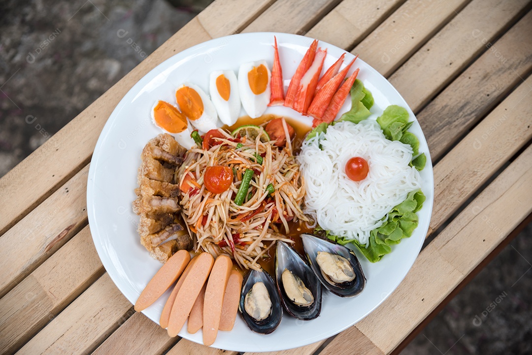 Prato de comida arroz salada legumes torresmo frito sobre uma mesa de madeira