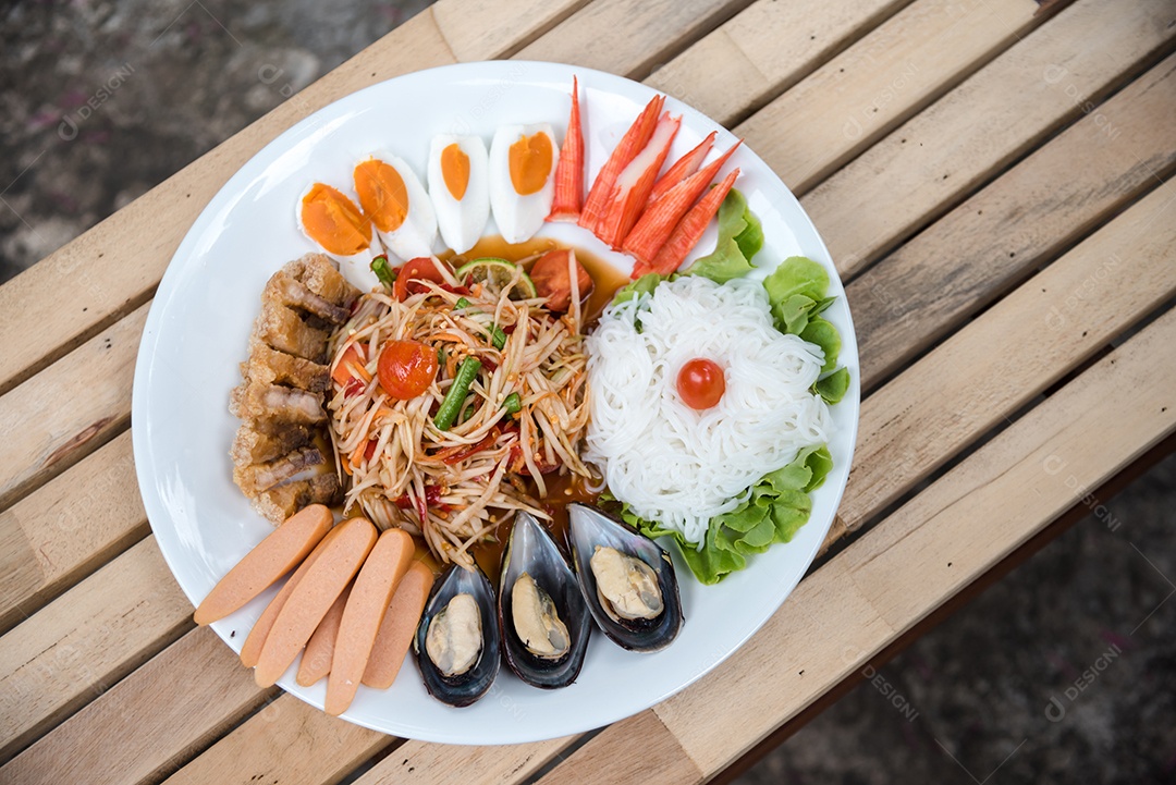 Prato de comida arroz salada legumes torresmo frito sobre uma mesa de madeira
