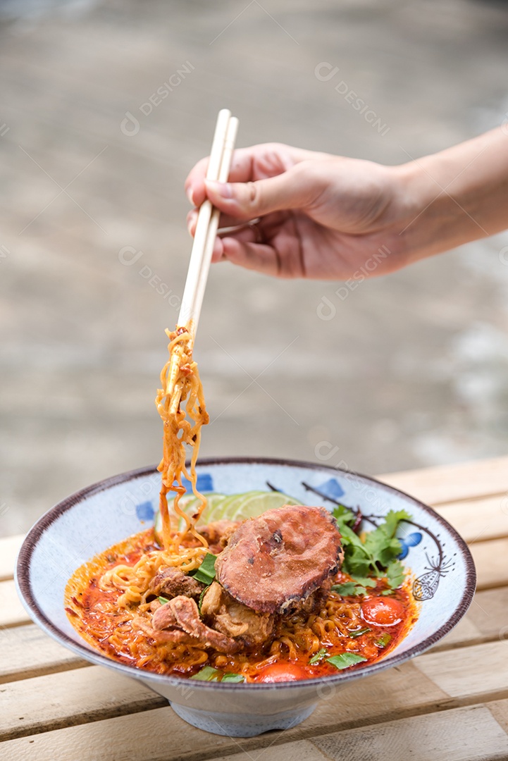 Yakisoba sobre uma tigela Mãos de pessoa pegando com Hashi