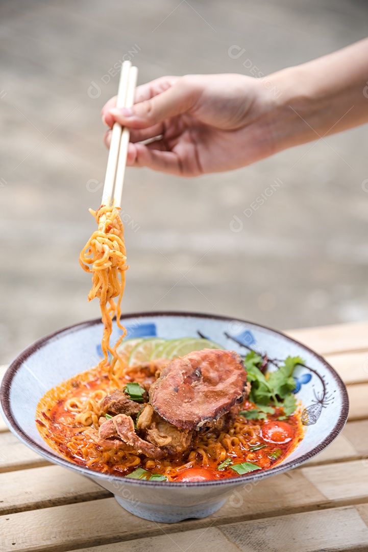 Yakisoba sobre uma tigela Mãos de pessoa pegando com Hashi