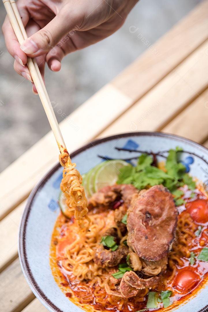 Yakisoba sobre uma tigela Mãos de pessoa pegando com Hashi