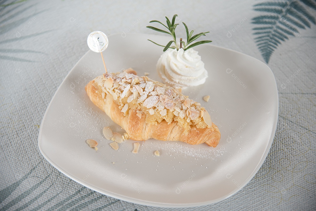 Pão sobre uma prato branco com chantily por cima