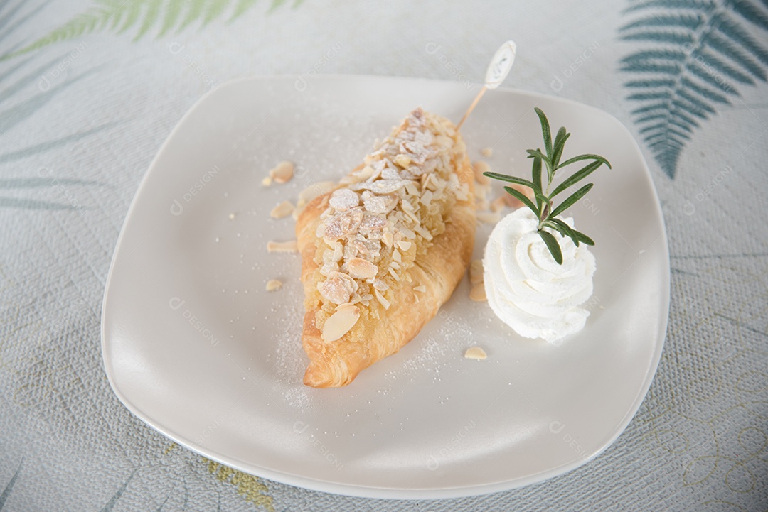 Pão sobre prato branco chantily sobre uma mesa madeira