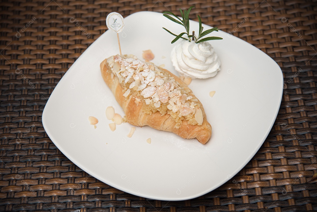 Pão sobre prato branco chantily sobre uma mesa madeira