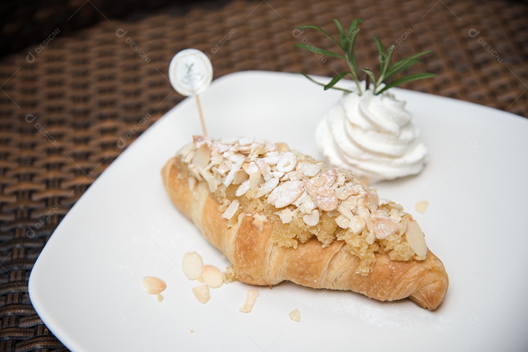 Pão sobre prato branco chantily sobre uma mesa madeira