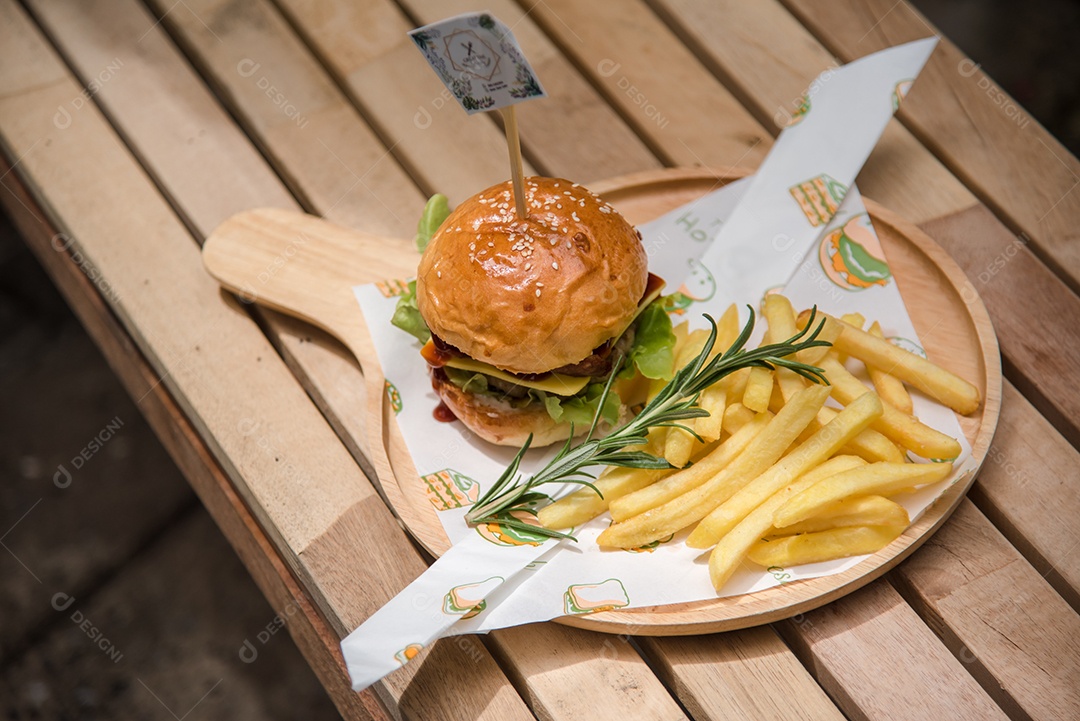 Hambúrgueres caseiros de carne queijo e legumes em uma velha mesa de madeira