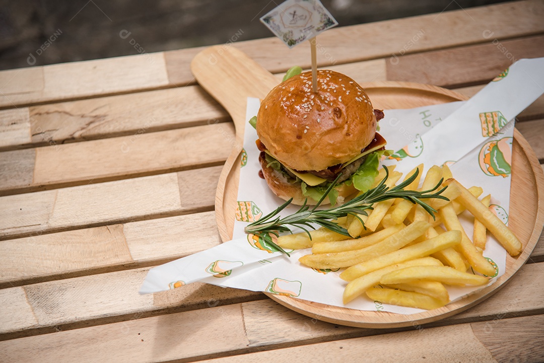 Hambúrgueres caseiros de carne queijo e legumes em uma velha mesa de madeira