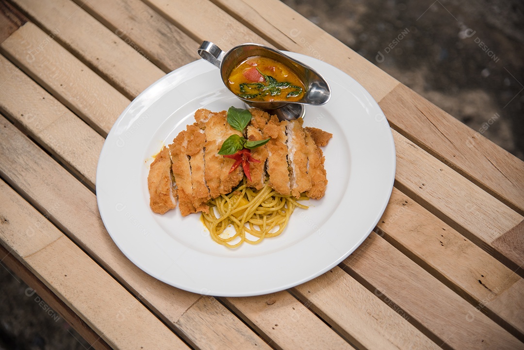 Prato de macarronada sobre prato branco mesa madeira