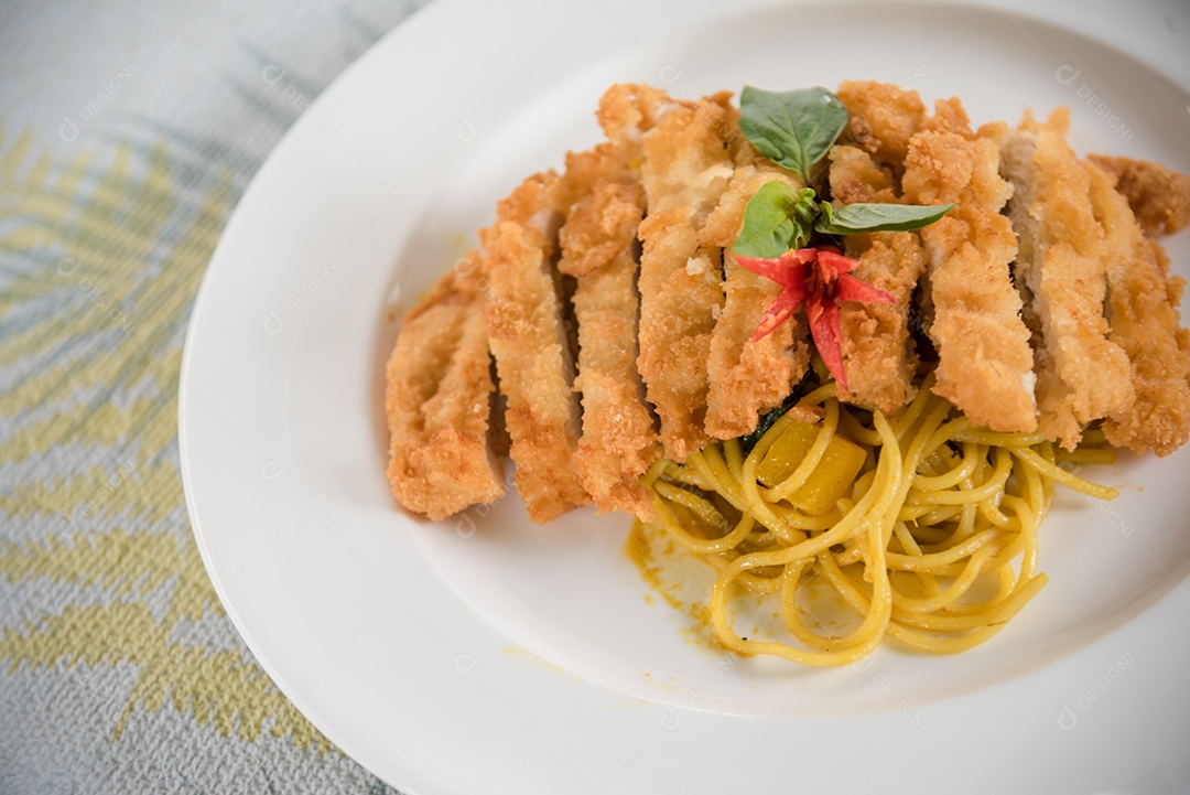 Prato de macarronada sobre prato branco mesa madeira