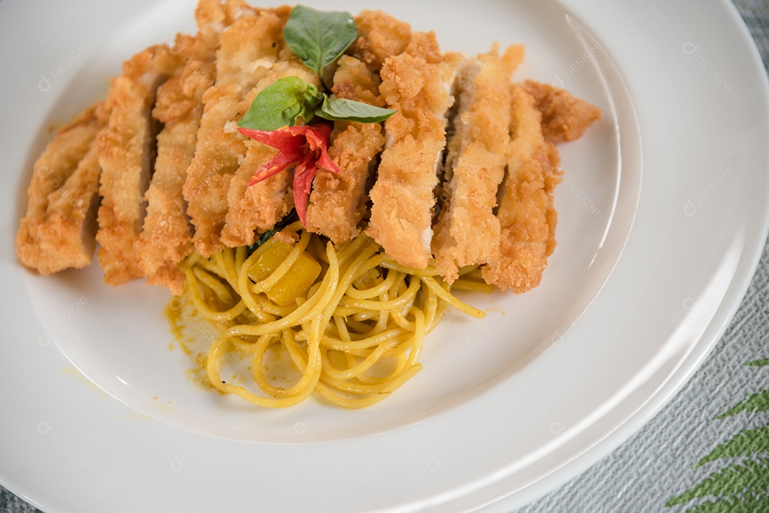 Prato de macarronada sobre prato branco mesa madeira