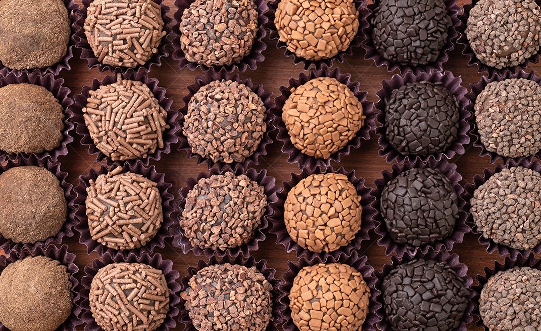 Brigadeiros brasileiros típicos, vários sabores em uma placa de madeira isolada