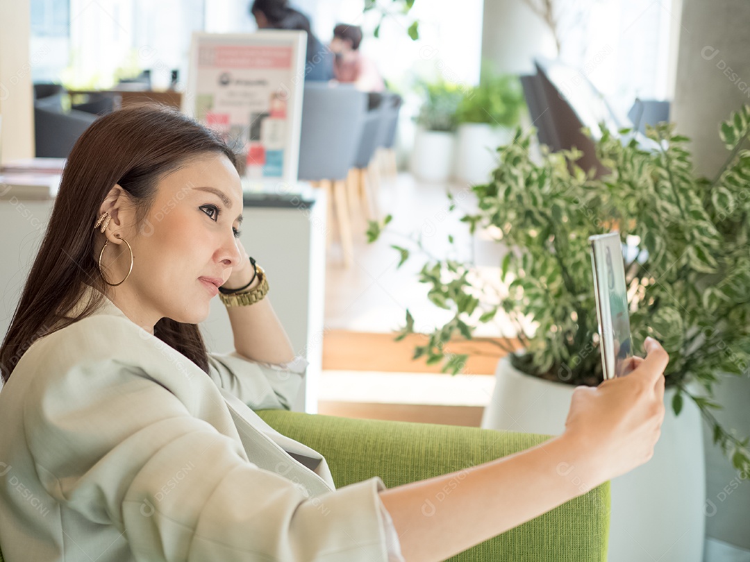 Mulher tirando self no escritório empresária