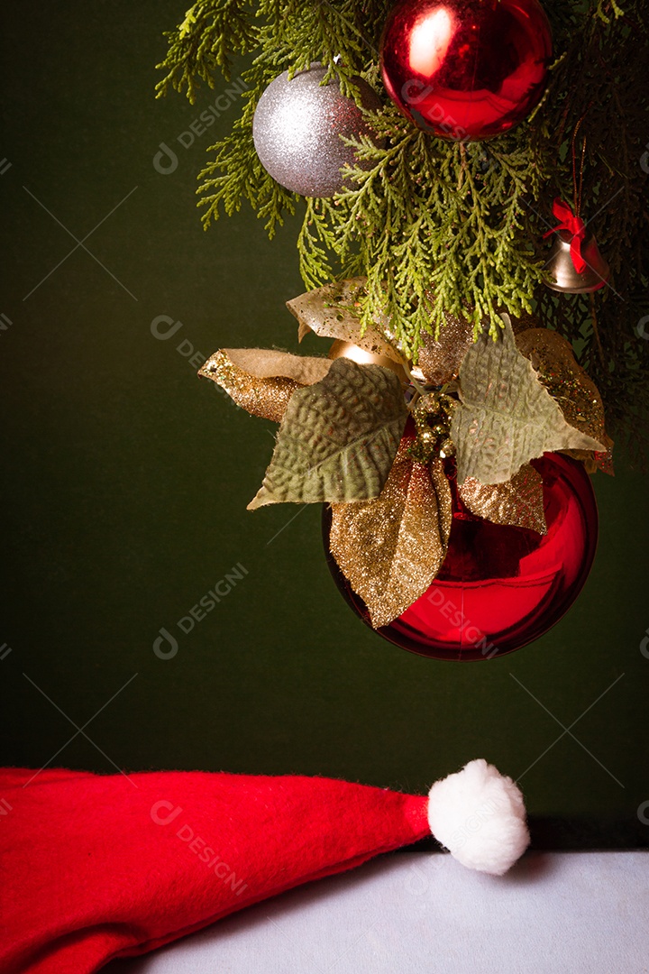 Bola de natal sobre arvore com touca vermelha sobre fundo isolado