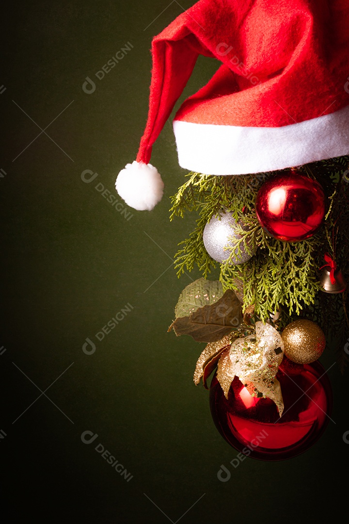 Bola de natal sobre arvore com touca vermelha sobre fundo isolado