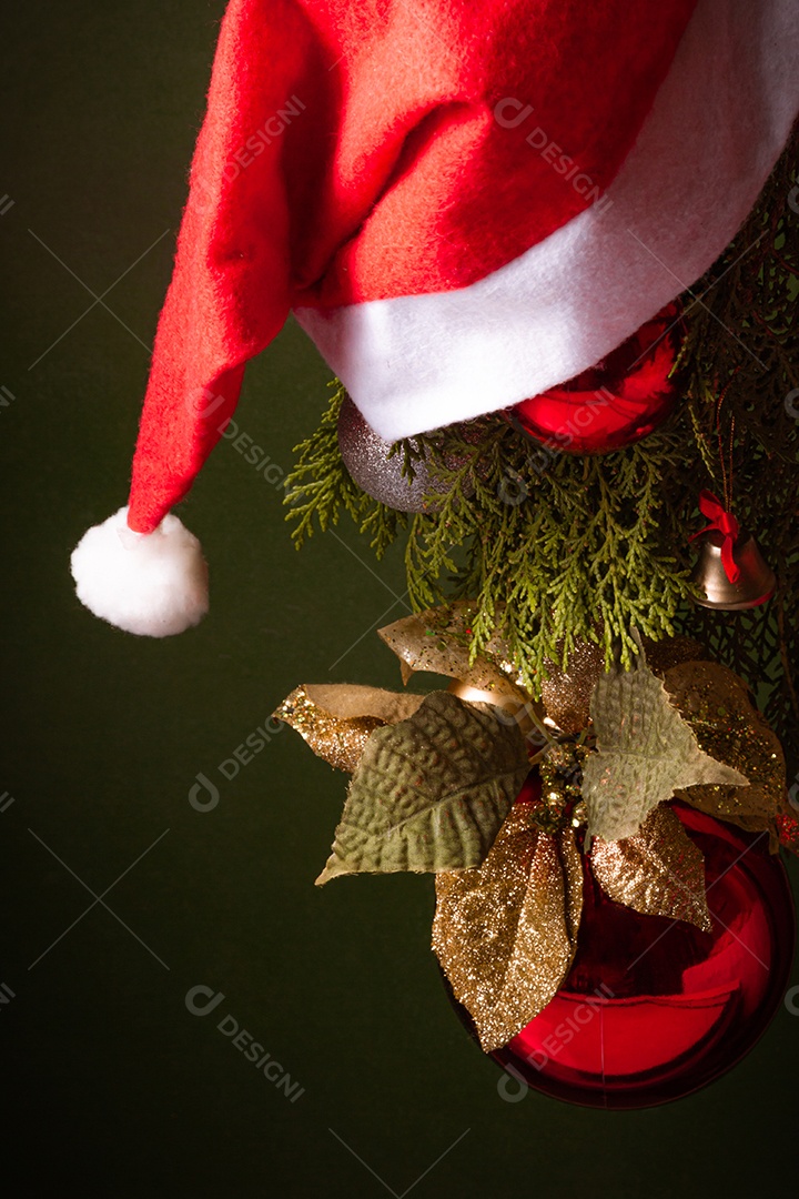 Bola de natal sobre arvore com touca vermelha sobre fundo isolado