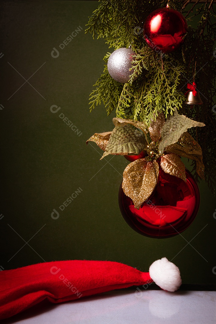 Bola de natal sobre arvore com touca vermelha sobre fundo isolado