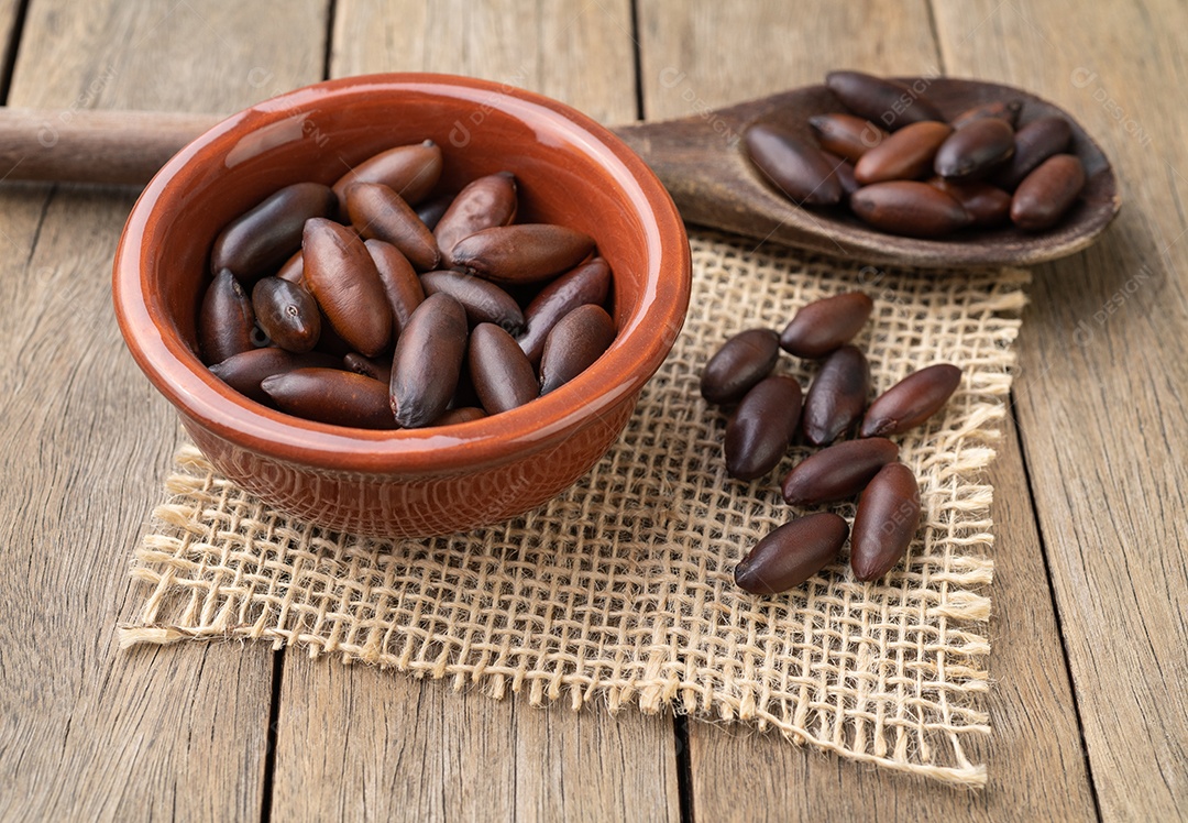Nozes de baru brasileiras em uma tigela sobre a mesa de madeira.
