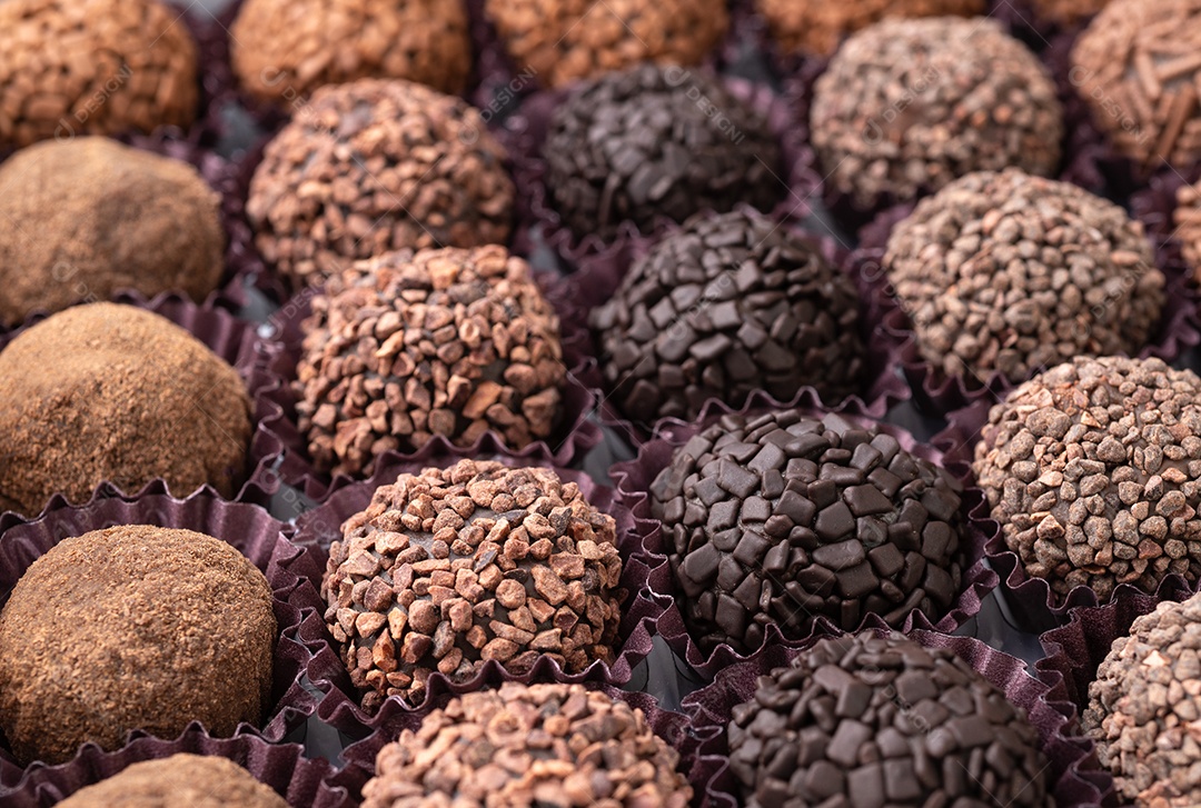 Brigadeiros brasileiros típicos, vários sabores em uma placa de madeira isolada