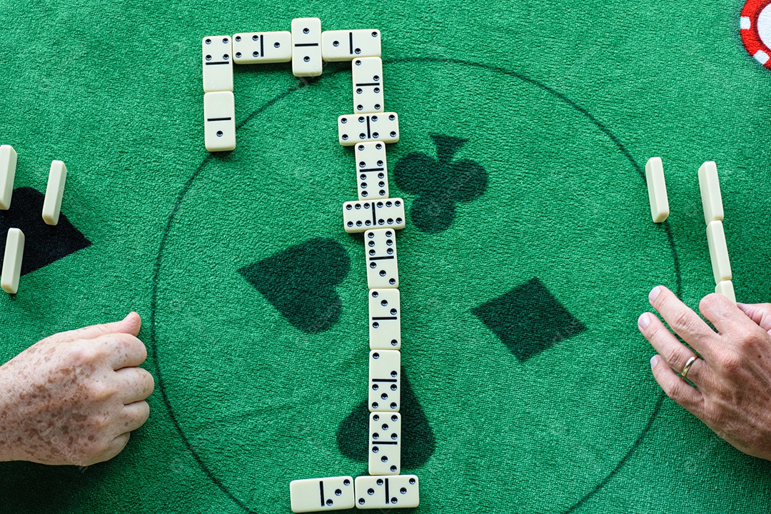 Dois homens em um jogo de dominó, peças dispostas no centro