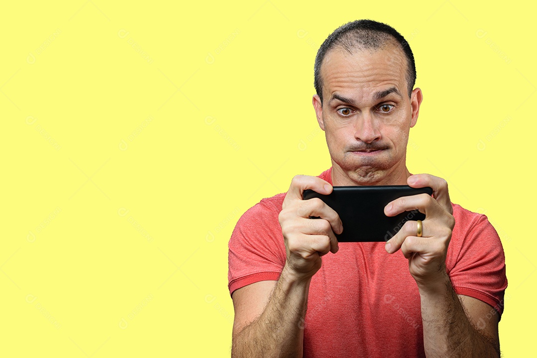 Homem maduro em roupas casuais jogando no smartphone