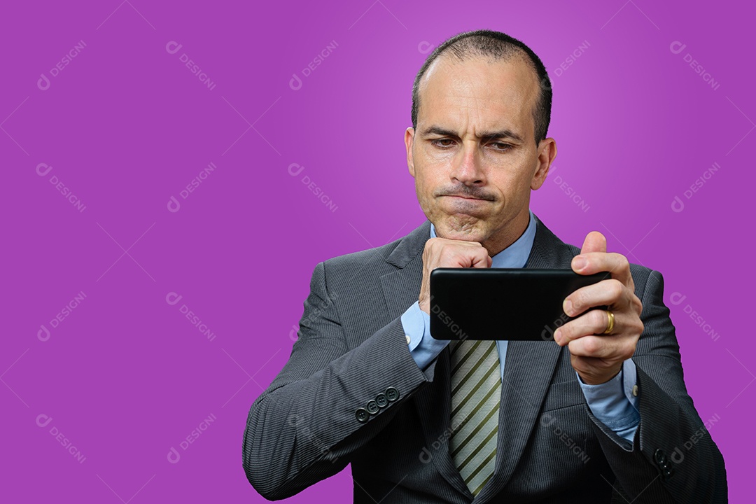 Homem maduro com terno e gravata, olhando para seu smartphone, desapontado