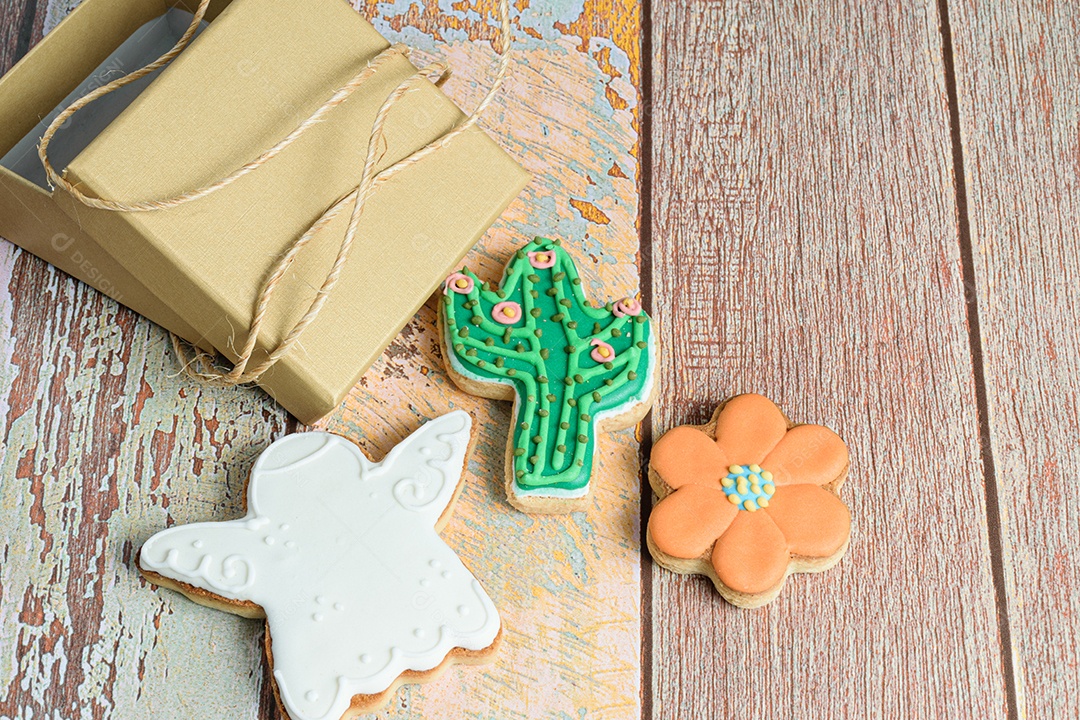 Biscoitos de anjo, flor e cacto ao lado de uma pequena caixa