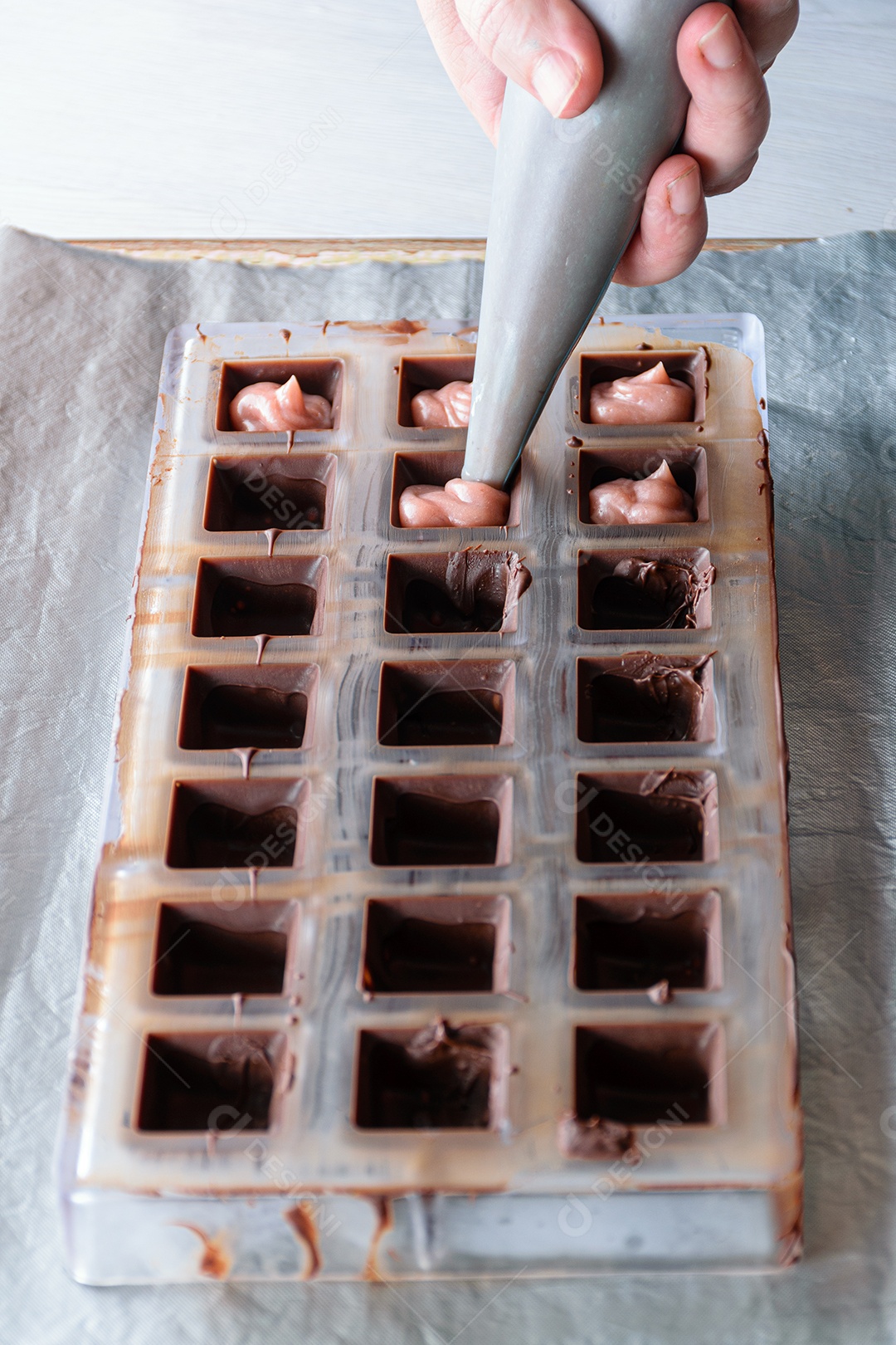 Usando o bico de confeiteiro para rechear bombons de chocolate com ganache