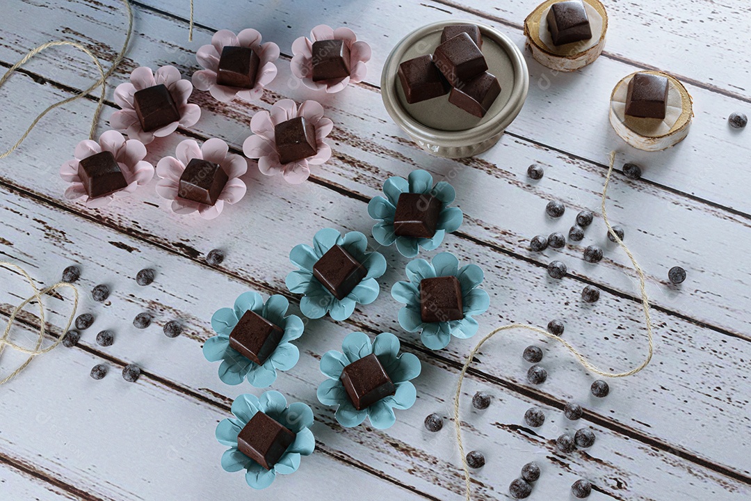 Bombons de chocolate recheados com ganache, sobre uma mesa branca
