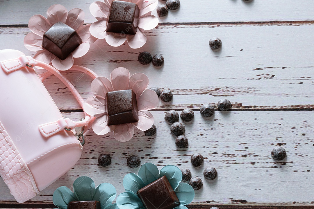Closeup de bombons de chocolate ao lado de um pequeno saco rosa deitado