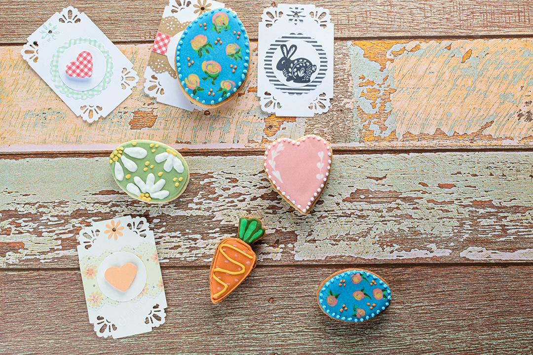 Ovo de Páscoa, biscoitos de coração e cenoura em uma mesa de madeira