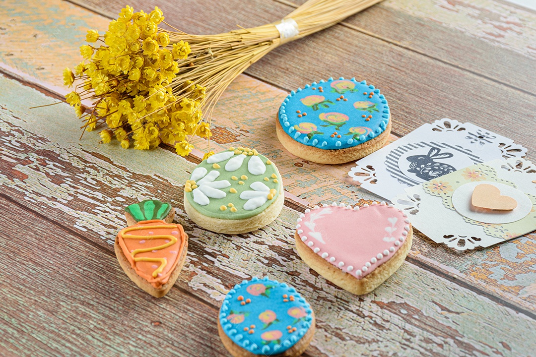 Ovo de Páscoa, biscoitos de coração e cenoura cercados por cartões de coração e coelho