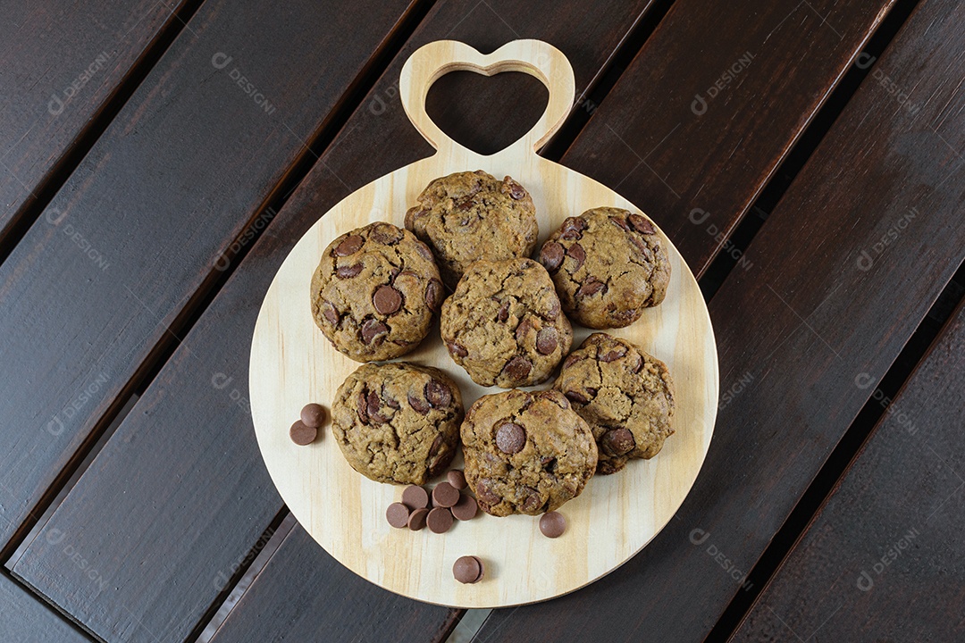Vários biscoitos em uma tabua redonda de madeira com o coração