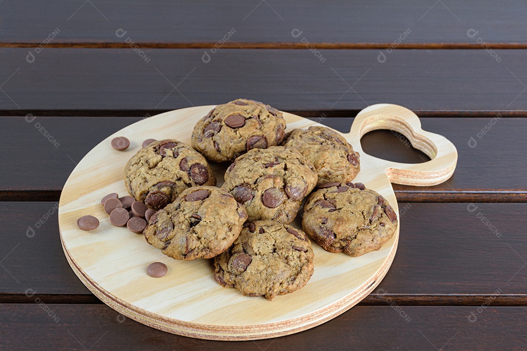 Aproximação de vários biscoitos em uma tábua redonda de madeira com o coração