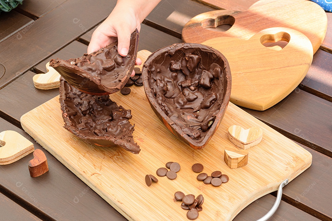 Criança pegando metade do ovo de Páscoa de chocolate amargo com amêndoas crocante