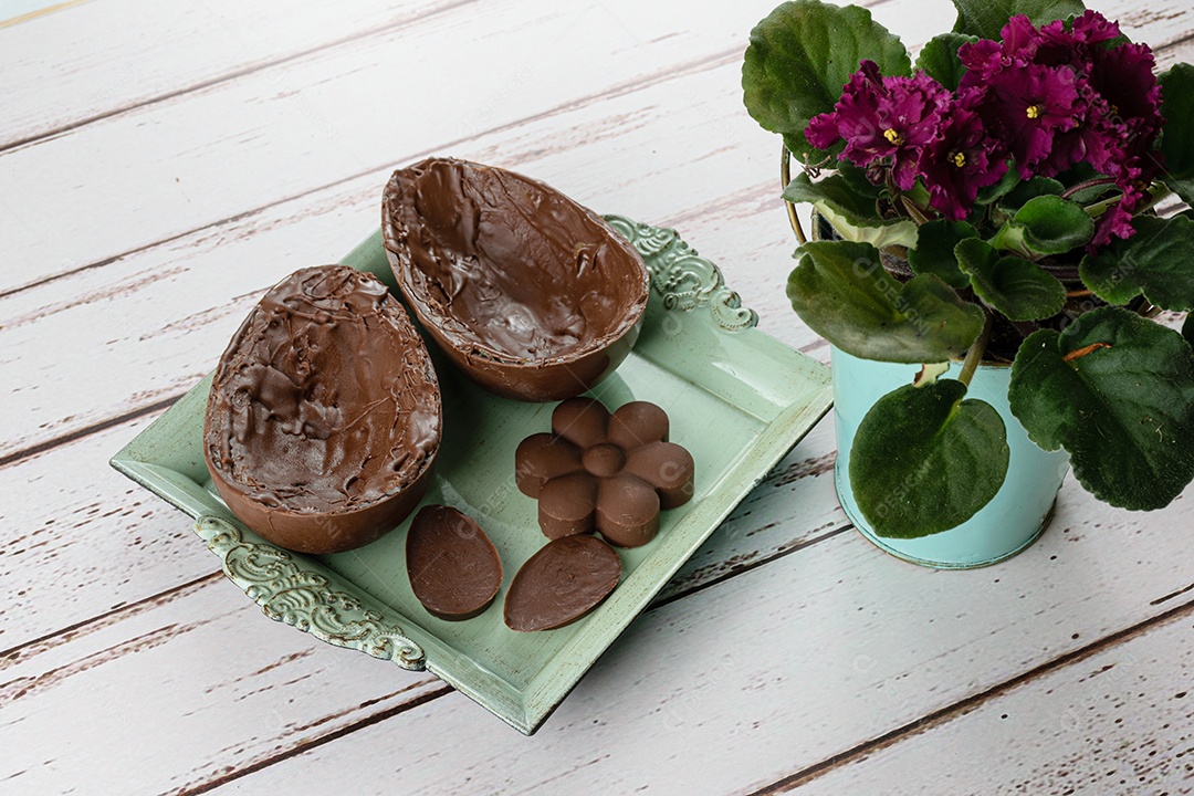 Duas metades de ovo de Páscoa de chocolate, em uma bandeja pequena e velha