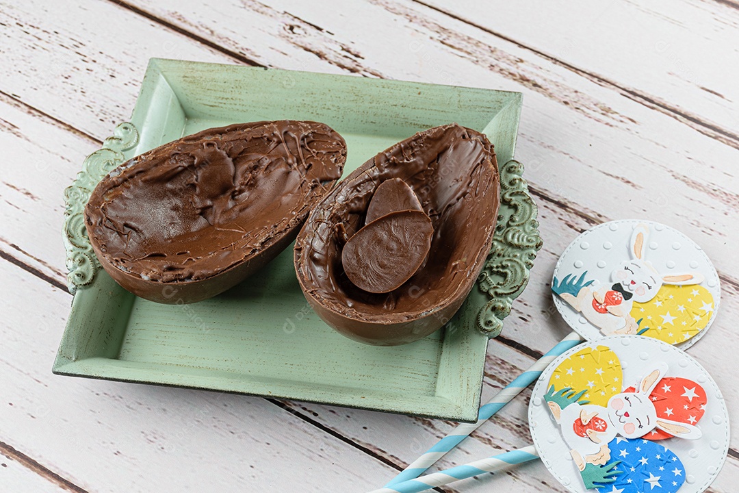 Duas metades de ovo de Páscoa de chocolate, em uma bandeja pequena e velha