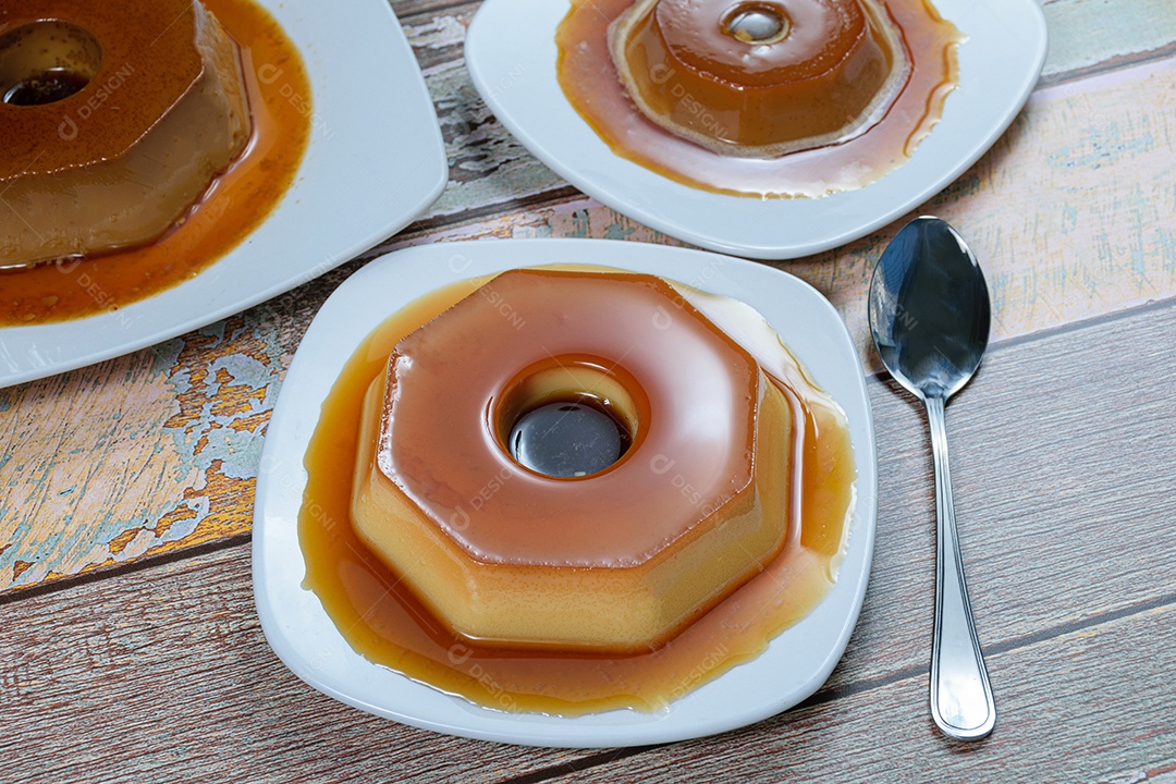Pudim de leite condensado com calda de caramelo, rodeado de outros