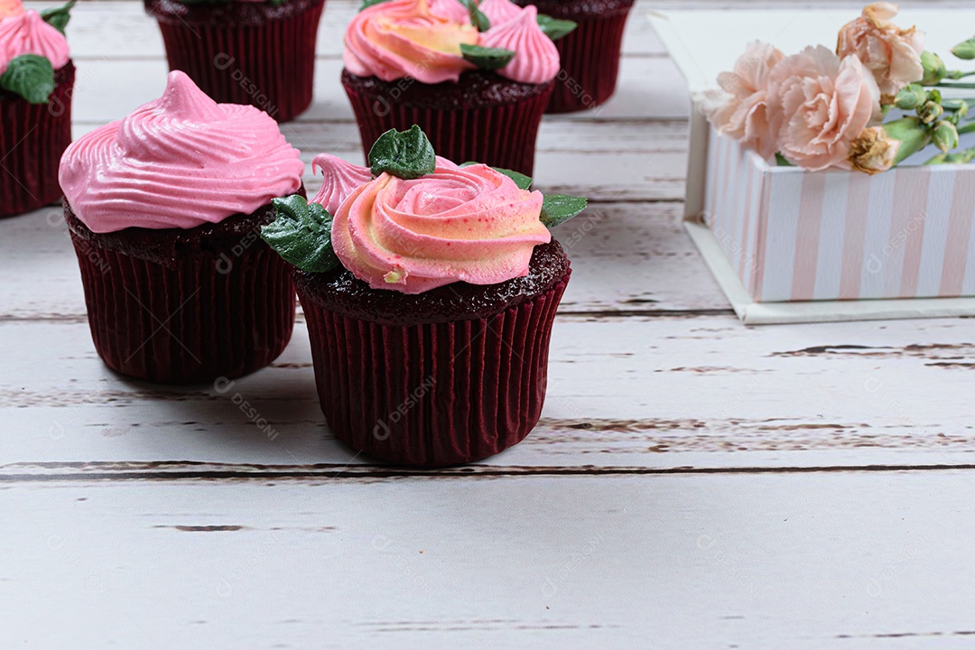 Closeup de cupcake de veludo vermelho com cobertura de creme de manteiga rosa