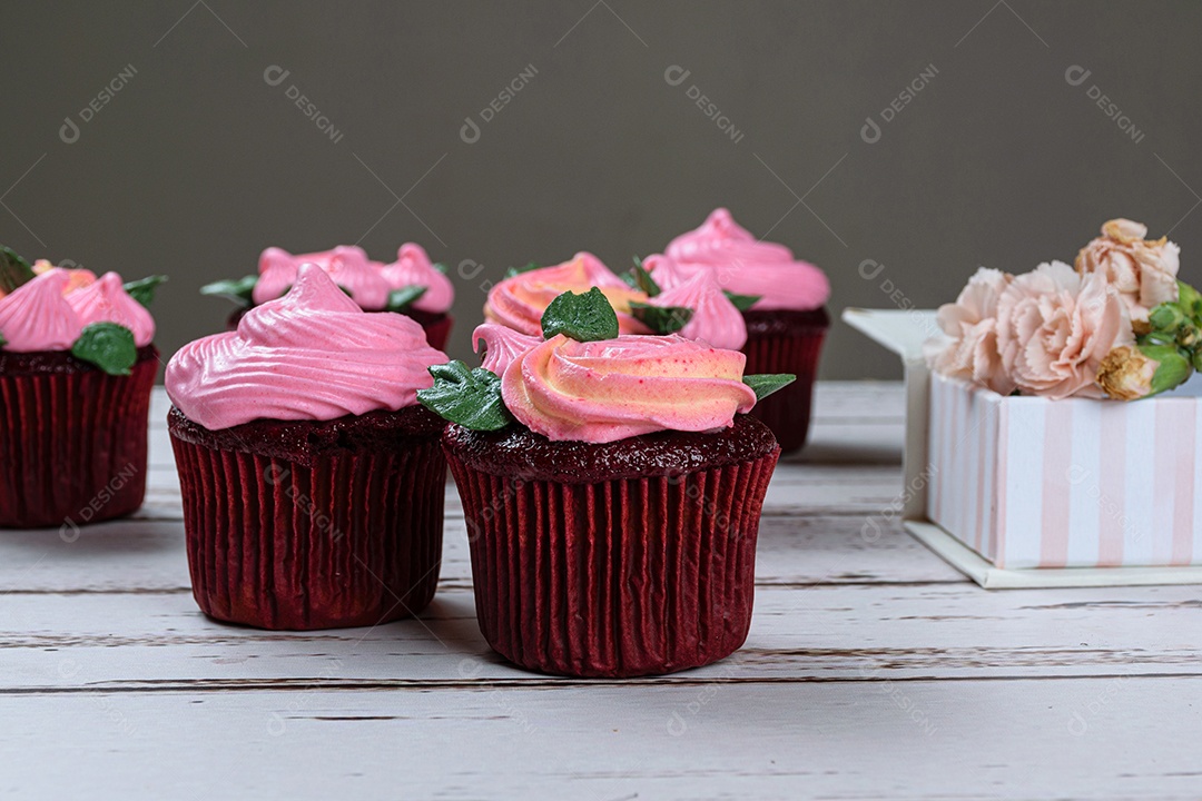 Closeup de cupcake de veludo vermelho com cobertura de creme de manteiga rosa