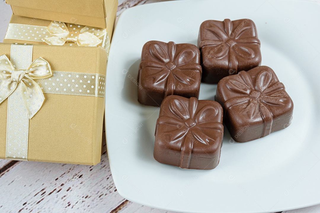 Quatro bolos de mel brasileiros ao lado de caixas de presente douradas